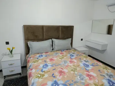 a bedroom with a large bed with a floral bedspread at Spacious Apartment in the heart of downtown Fez in Fès