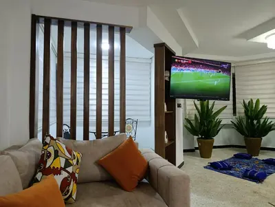 a living room with a couch and a flat screen tv at Spacious Apartment in the heart of downtown Fez in Fès
