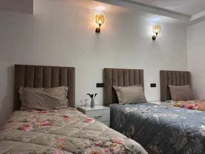 a bedroom with two beds and two lights on the wall at Spacious Apartment in the heart of downtown Fez in Fès