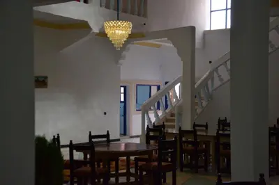 a dining room with a table and chairs and stairs at La Belle Vue Guest House in Aït Ben Haddou