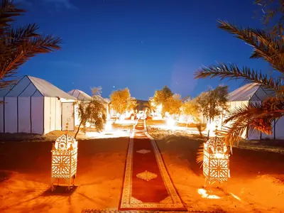 a night view of a compound with trees and lights at enjoy best night in desert merzouga in Merzouga