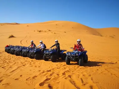 a group of people riding atvs in the desert at enjoy best night in desert merzouga in Merzouga