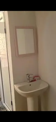 a bathroom with a white sink and a mirror at Yamna Cozy Cave in Bhalil
