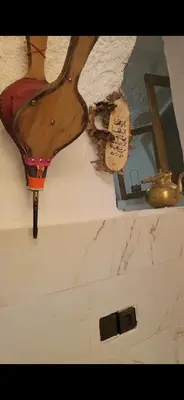 a wooden spoon hanging on the wall of a room at Yamna Cozy Cave in Bhalil