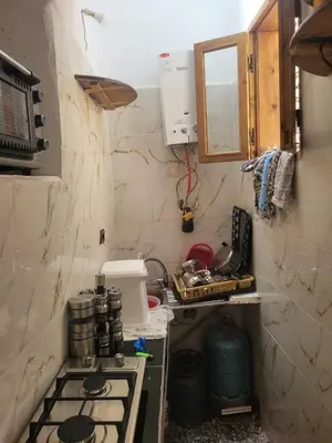 a small kitchen with a stove and a sink at Yamna Cozy Cave in Bhalil