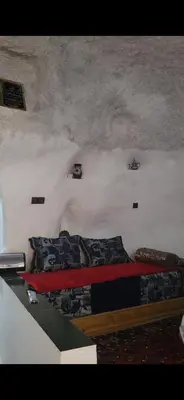 a room with two beds in the corner of a room at Yamna Cozy Cave in Bhalil