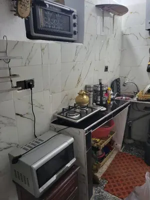 a kitchen with a stove and a microwave at Yamna Cozy Cave in Bhalil