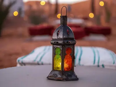 a bottle with a candle in it sitting on a table at Merzouga Soul Camp in Merzouga
