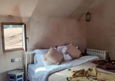 a small bedroom with a bed and a window at Merzouga Soul Camp in Merzouga