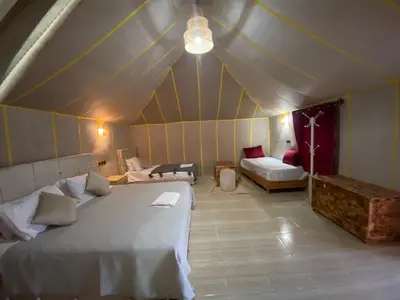 a large room with two beds and a couch at Merzouga Soul Camp in Merzouga