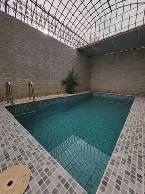 a swimming pool with a glass ceiling and a tile floor at Villa Enouzha in Fès