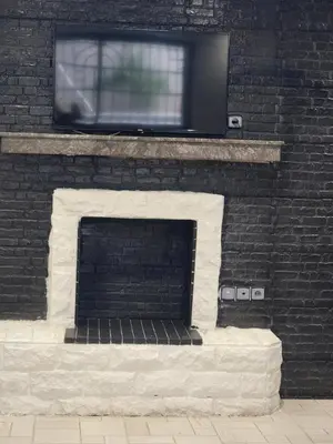 a tv sitting on top of a brick fireplace at Villa Enouzha in Fès