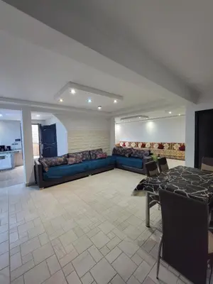 a living room with a blue couch and a table at Villa Enouzha in Fès