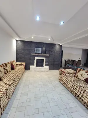 a living room with two couches and a fireplace at Villa Enouzha in Fès