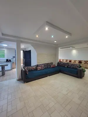 a large living room with a blue couch in a room at Villa Enouzha in Fès