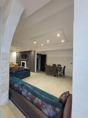 a living room with couches and a dining room at Villa Enouzha in Fès