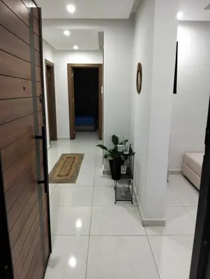 a hallway with a door and a living room at Apartment Sea view Toudert Anza Agadir in Oulad Akkou