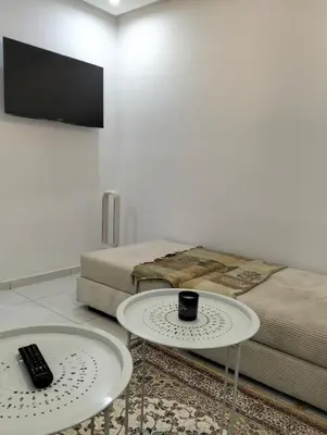 two tables in a room with two beds and a tv at Apartment Sea view Toudert Anza Agadir in Oulad Akkou