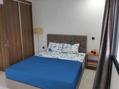 a bedroom with a bed with a blue bedspread at Apartment Sea view Toudert Anza Agadir in Oulad Akkou
