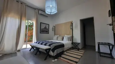 a bedroom with a bed and a large window at Villa Roseaux heated pool Marrakech in Najem