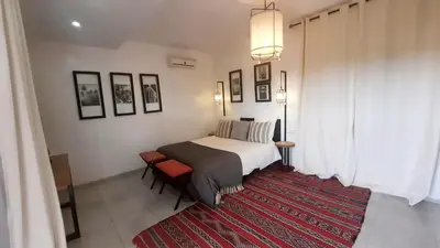 a bedroom with a bed and a red rug at Villa Roseaux heated pool Marrakech in Najem