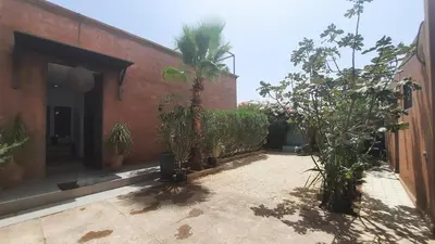 a courtyard with trees and a brick building at Villa Roseaux heated pool Marrakech in Najem