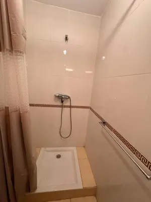 a small bathroom with a shower with a shower curtain at Appartement Spacieux et cosy in Chouiter
