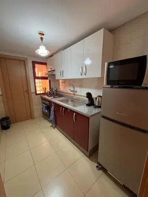 a kitchen with a sink and a refrigerator at Appartement Spacieux et cosy in Chouiter