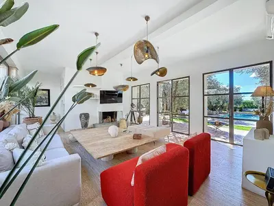 a living room with red chairs and a table at Villa Paschmina, petit-déjeuner inclus in Ourika