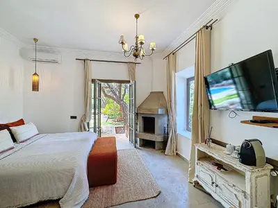 a bedroom with a bed and a flat screen tv at Villa Paschmina, petit-déjeuner inclus in Ourika