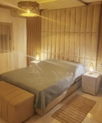 a bedroom with a large bed and two night stands at Smart home oumnia in Fès