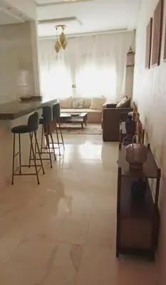 a living room with a couch and a table and chairs at Smart home oumnia in Fès