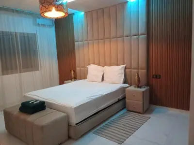 a bedroom with a bed and a chair and a bed sidx sidx sidx at Smart home oumnia in Fès