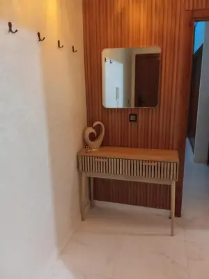 a bathroom with a tv and a wooden wall at Smart home oumnia in Fès