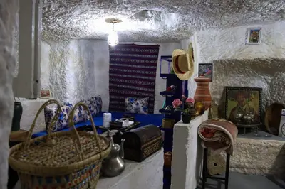 a room with baskets and a table and a wall at كهوف يحيى لسياحة والمبيت البهاليل in Bhalil