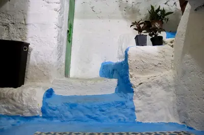 a blue and white stairway with a plant on it at كهوف يحيى لسياحة والمبيت البهاليل in Bhalil