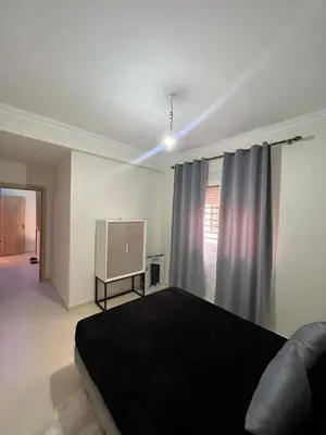 a bedroom with a bed and a flat screen tv at sale in Oulad Akkou