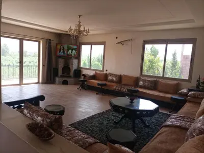 a living room with a couch and a fireplace at Villa Atlas View in Aghmat