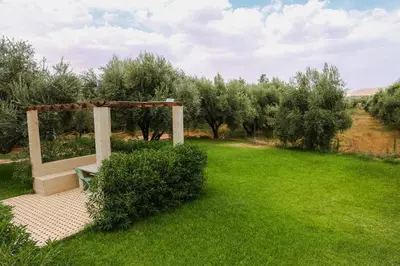 a park with a bench in a field of grass at Villa Atlas View in Aghmat