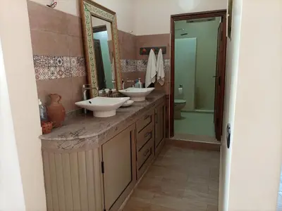 a bathroom with two sinks and a mirror at Villa Atlas View in Aghmat