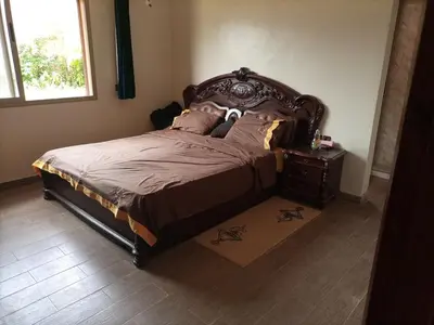 a bedroom with a large bed with a wooden headboard at Villa Atlas View in Aghmat
