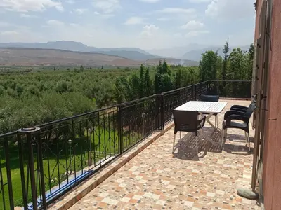 a patio with a table and chairs on a balcony at Villa Atlas View in Aghmat