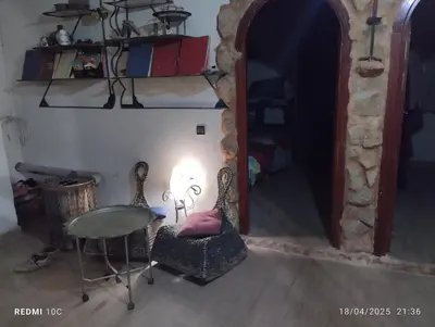 a room with a table and a chair and a lamp at Authentic Guesthouse with Garden and Mountain View Beni Mellal in Beni Mellal