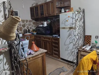 a kitchen with a white refrigerator and wooden cabinets at Authentic Guesthouse with Garden and Mountain View Beni Mellal in Beni Mellal