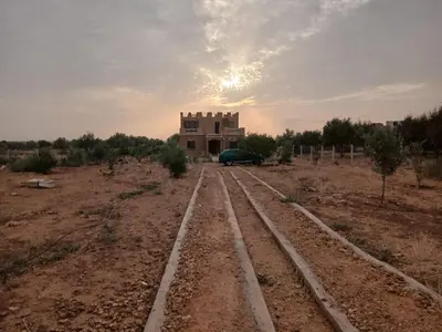 a building in the middle of a desert with train tracks at Authentic Guesthouse with Garden and Mountain View Beni Mellal in Beni Mellal