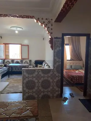 a living room with a large mirror and a bedroom at مكناس مريم in Meknès