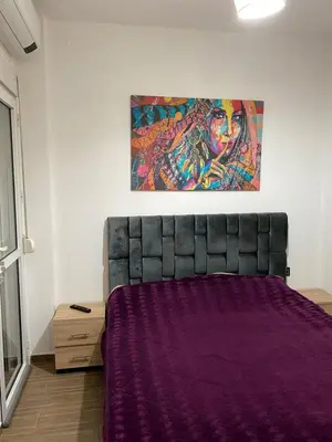 a bed in a room with a painting on the wall at Joude in Fès