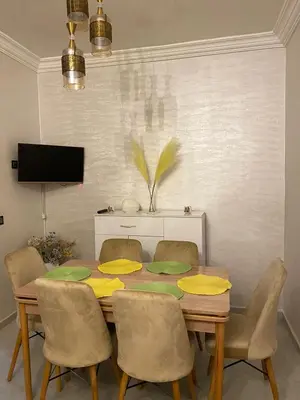 a dining room table with chairs and a television at Joude in Fès