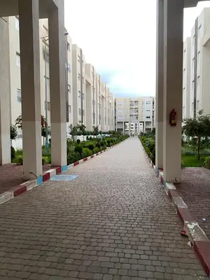 an empty street in a city with tall buildings at Joude in Fès