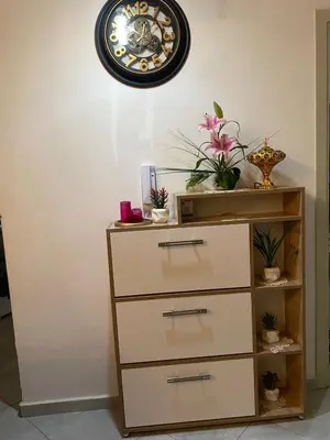 a clock hanging on a wall above a dresser at Joude in Fès